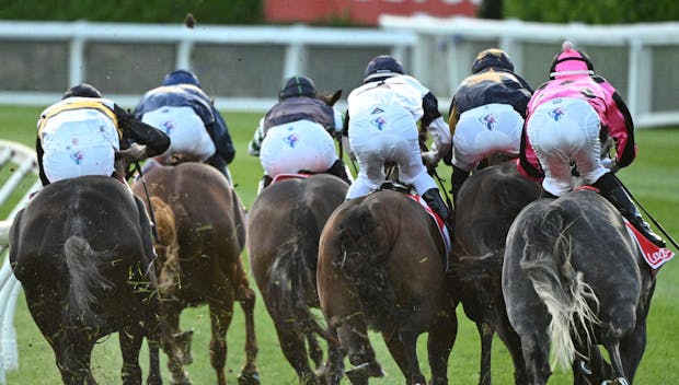 MELBOURNE, AUSTRALIA - DECEMBER 15: Horses and riders bunched up on the home turn in Race 4, the Ladbrokes 55 Second Challenge - Heat 9 during Melbourne Racing at Moonee Valley Racecourse on December 15, 2023 in Melbourne, Australia. (Photo by