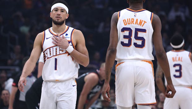 LOS ANGELES, CALIFORNIA - APRIL 10: Devin Booker #1 of the Phoenix Suns reacts as he walks past Kevin Durant #35 during the first half against the LA Clippers at Crypto.com Arena on April 10, 2024 in Los Angeles, California. User is consenting to the terms and conditions of the Getty Images License Agreement. (Photo by Harry How/Getty Images)